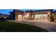 Modern home exterior with large garage doors, paver driveway, lush lawn and sleek design at 12199 Canyon Sunset St, Las Vegas, NV 89138