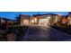 Beautiful modern home exterior with large garage doors, paver driveway and desert landscaping at 12199 Canyon Sunset St, Las Vegas, NV 89138