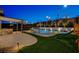 Lush backyard with a sparkling pool, outdoor kitchen, play area and relaxing ambiance for ultimate enjoyment at 12199 Canyon Sunset St, Las Vegas, NV 89138