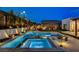 Luxurious pool with a built-in hot tub, elegant landscaping, and ambient lighting for evening enjoyment at 12199 Canyon Sunset St, Las Vegas, NV 89138