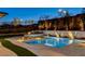 Beautifully lit backyard pool and spa area featuring lush landscaping and a modern privacy wall at 12199 Canyon Sunset St, Las Vegas, NV 89138