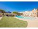 Large lush backyard featuring a stunning pool, patio set, and manicured green lawn for entertaining at 1709 Chapman Dr, Las Vegas, NV 89104