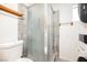 A bathroom featuring a glass shower stall, toilet, towel bars, and stackable washer dryer unit at 1709 Chapman Dr, Las Vegas, NV 89104