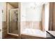 A luxurious bathroom with a shower and separate tub, accented by a stylish chandelier and natural light for a spa experience at 1709 Chapman Dr, Las Vegas, NV 89104