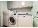 A well-equipped laundry room with modern appliances, gray cabinets and decorative backsplash offers convenience and style at 1709 Chapman Dr, Las Vegas, NV 89104