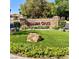 Welcoming entrance to Spanish Oaks, with lush landscaping, mature trees, and decorative rock at 1801 Calle De Vega, Las Vegas, NV 89102