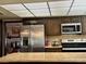 Kitchen with stainless steel refrigerator, dark cabinetry, and granite counters at 1801 Calle De Vega, Las Vegas, NV 89102