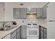 Functional kitchen with white appliances, grey cabinets, and ample countertop space at 1881 W Alexander Rd # 1135, North Las Vegas, NV 89032