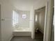 Bathroom featuring a soaking tub with a round window above and neutral flooring at 2282 Camel Mesa Dr, Laughlin, NV 89029