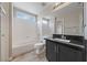 Bathroom featuring single vanity sink with a black granite countertop, bathtub, and shower at 274 Pear Meadow St, Henderson, NV 89012