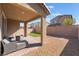 Backyard featuring a covered patio with seating, artificial turf, and brick pavers at 2878 Chalk Mountain Ct, Las Vegas, NV 89142