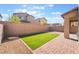 Backyard featuring a covered patio, artificial turf, and a brick privacy wall at 2878 Chalk Mountain Ct, Las Vegas, NV 89142