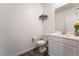 Clean half-bathroom with a sleek single vanity, modern toilet, and stylish wall decor at 2878 Chalk Mountain Ct, Las Vegas, NV 89142