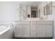 Modern bathroom with double sinks, white cabinetry, and a separate shower at 2878 Chalk Mountain Ct, Las Vegas, NV 89142