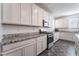 Modern kitchen with stainless steel appliances, white cabinets and elegant granite countertops at 2878 Chalk Mountain Ct, Las Vegas, NV 89142