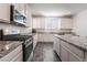 Modern kitchen with stainless steel appliances, white cabinets and elegant granite countertops at 2878 Chalk Mountain Ct, Las Vegas, NV 89142