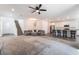 Open concept living room with a staircase, white kitchen, and ceiling fan at 2878 Chalk Mountain Ct, Las Vegas, NV 89142