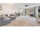 Open-concept living room with a modern gray sofa, recessed lighting, and sliding glass doors at 2878 Chalk Mountain Ct, Las Vegas, NV 89142