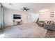 Spacious living room with plush gray carpet, large sectional, and modern ceiling fan and shelves at 2878 Chalk Mountain Ct, Las Vegas, NV 89142