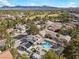 Enjoy a stunning aerial view of the property with a pool, lush landscaping, and mountain views at 3010 La Mesa Dr, Henderson, NV 89014