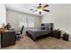 Comfortable bedroom featuring a ceiling fan, dark wood furnishings, and natural light at 3010 La Mesa Dr, Henderson, NV 89014