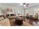 Spacious living room with hardwood floors, neutral walls, ceiling fan, and elegant furniture at 3010 La Mesa Dr, Henderson, NV 89014