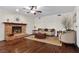 Inviting living room with fireplace, hardwood floors, ceiling fan, and comfortable seating arrangements at 3010 La Mesa Dr, Henderson, NV 89014