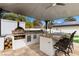 Well-appointed outdoor kitchen boasts a pizza oven, grill, and bar seating, ideal for culinary enthusiasts at 3010 La Mesa Dr, Henderson, NV 89014