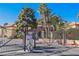 View of the secure community entrance gate and surrounding landscaping with mature trees at 3135 S Mojave Rd # 241, Las Vegas, NV 89121