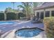 Community pool and hot tub area surrounded by lush landscaping and lounge seating at 3135 S Mojave Rd # 241, Las Vegas, NV 89121
