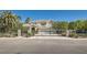 Charming two-story home with a well-manicured lawn, secure black metal gate, and beautiful palm trees at 3560 Five Pennies Ln, Las Vegas, NV 89120