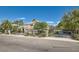 Charming two-story home with a well-manicured lawn, secure black metal gate, and beautiful palm trees at 3560 Five Pennies Ln, Las Vegas, NV 89120