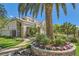 Beautiful front yard with a flower bed, healthy trees, stone pathway, and view of the two-story home at 3560 Five Pennies Ln, Las Vegas, NV 89120