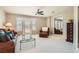 Cozy living room filled with natural light has a ceiling fan, plush seating, and neutral carpet at 3560 Five Pennies Ln, Las Vegas, NV 89120