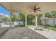Covered patio with stone flooring, ceiling fan, outdoor seating and a grill in landscaped yard at 3560 Five Pennies Ln, Las Vegas, NV 89120