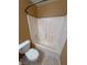 Bathroom featuring a white tub and toilet, set against light brown walls and neutral tile flooring at 3580 Unicorn Ave, Pahrump, NV 89048