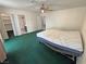 A bedroom featuring green carpet, a ceiling fan, a closet, and an adjacent bathroom at 3580 Unicorn Ave, Pahrump, NV 89048