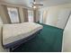 Large bedroom with green carpet, a ceiling fan, and sliding glass doors leading to the backyard at 3580 Unicorn Ave, Pahrump, NV 89048