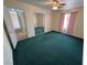 This bedroom has green carpet, a ceiling fan, a window with pink curtains, and a mirrored closet at 3580 Unicorn Ave, Pahrump, NV 89048
