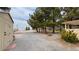 Expansive property featuring a well-kept lawn, various trees, storage sheds, and a gravel driveway at 3580 Unicorn Ave, Pahrump, NV 89048