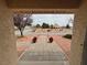 View from covered front porch; landscape features desert rock and gravel, potted plants, and small trees at 3580 Unicorn Ave, Pahrump, NV 89048