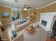 Staged living room featuring a fireplace, ceiling fan, neutral colored walls, and connected dining and kitchen areas at 3580 Unicorn Ave, Pahrump, NV 89048