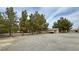 Expansive yard with mature trees and gravel ground cover, creating a serene outdoor setting at 3580 Unicorn Ave, Pahrump, NV 89048