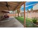 Cozy backyard featuring a covered patio with a swing, artificial grass, and privacy fence at 3934 Sir Payne Ct, Las Vegas, NV 89104