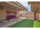Backyard with a covered patio, artificial grass, and a charming swing for relaxing outdoor living at 3934 Sir Payne Ct, Las Vegas, NV 89104