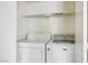 Convenient laundry room features a washing machine and a dryer with a storage shelf at 3934 Sir Payne Ct, Las Vegas, NV 89104