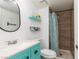 Stylish bathroom featuring a vanity with a turquoise cabinet, a modern mirror, and a tiled walk-in shower at 5010 Mick Pl, Las Vegas, NV 89103