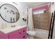 Bright bathroom with pink vanity, round mirror, and shower with stylish tile at 5010 Mick Pl, Las Vegas, NV 89103