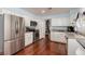 Bright kitchen with stainless steel appliances, white cabinets, and granite countertops; hardwood floors at 5010 Mick Pl, Las Vegas, NV 89103