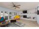 Spacious living room with a white brick fireplace, French doors, ceiling fan, and a view of the backyard at 5010 Mick Pl, Las Vegas, NV 89103